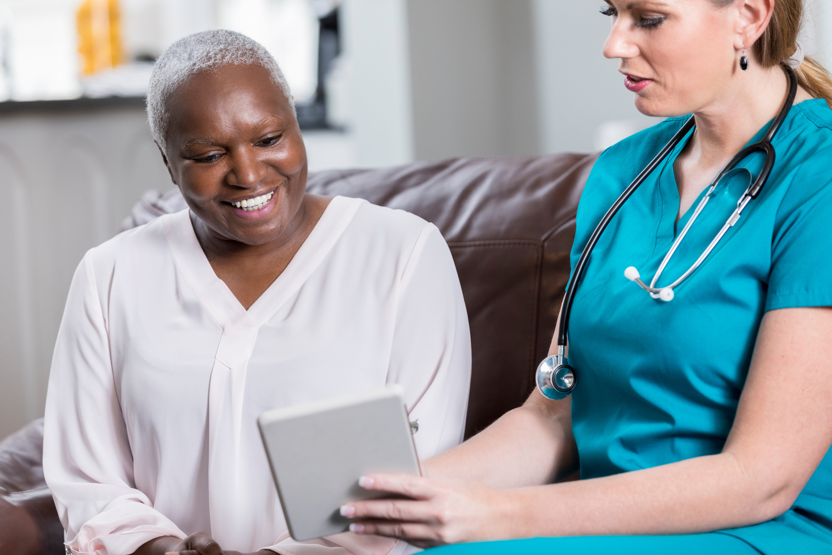 Home healthcare nurse reviews information with patient